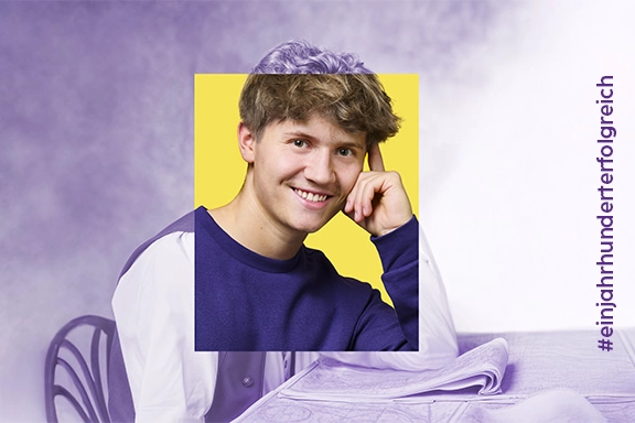 Mann in Lila auf gelbem Hintergrund vor historischem Bild mit Hashtag #einjahrhunderterfolgreich.